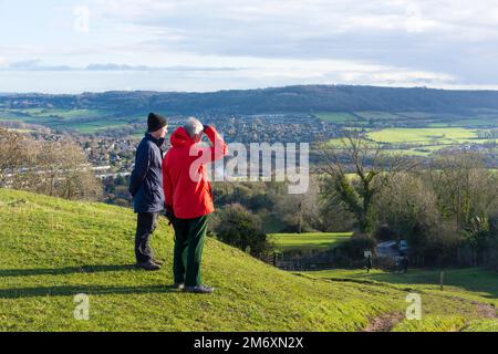 Walkers look out from atop Little Solsbury Hill, Batheaston, Somerset, UK Stock Photo