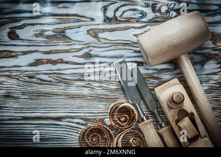 Lump hammer chisels planer curled shavings on wood board. Stock Photo