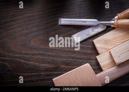 Lump hammer flat chisels and wooden bricks on brown vintage wood board copy space image construction concept. Stock Photo