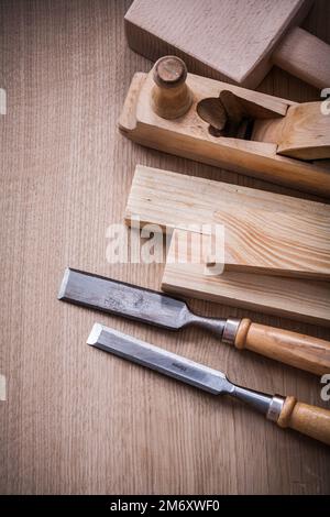 Hand mallet shaving plane metal chisels and wooden stud on brown board construction concept. Stock Photo