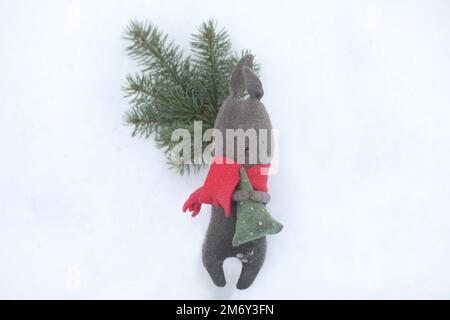 Black toy rabbit as symbol 2023 on white snow background. Christmas and Happy New Year concept. Chinese Rabbit 2023 Stock Photo