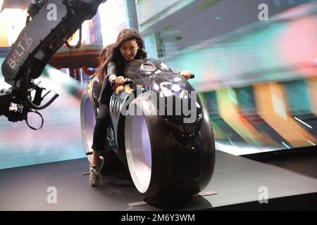 Las Vegas, United States. 05th Jan, 2023. A participant is filmed while she rides a futuristic motorcyle infront of a large LED screen at the 'Unreal Ride' display at the Nikon booth during the 2023 International CES, at the Las Vegas Convention Center in Las Vegas, Nevada on Thursday, January 5, 2023. Credit: UPI/Alamy Live News Stock Photo