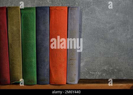 Home library of old battered retro books with colored spines Stock Photo