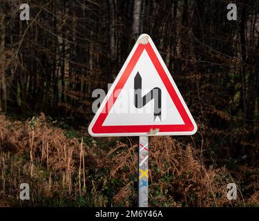 Dangerous turns, triangle warning traffic sign near rural road Stock Photo  - Alamy