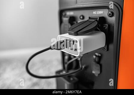 Inverter generator charges the power bank battery. Stock Photo