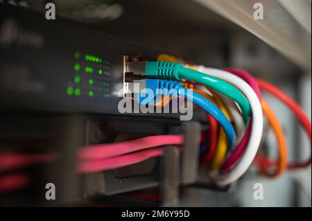 Switch with colorful LAN cables in a network cabinet of a data center Stock Photo