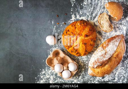 Bakery background with set of different freshly baked crispy bread and eggs on flour kitchen table Stock Photo