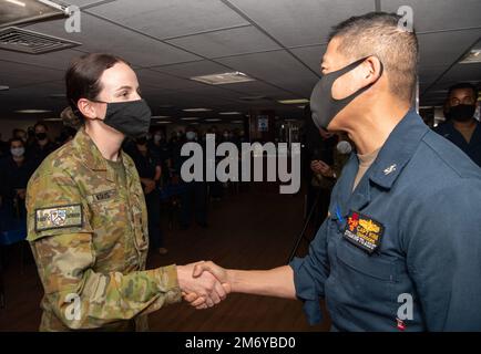 PACIFIC OCEAN (May 10, 2022) Captain Hank Kim, Pacific Partnership 2022 (PP22) mission commander (right), shakes hands with Australian Army Captain Isabella Negus after her promotion ceremony aboard the Military Sealift Command hospital ship USNS Mercy (T-AH 19), May 10 while underway for PP22. Now, in its 17th year, Pacific Partnership is the largest annual multinational humanitarian assistance and disaster relief preparedness mission conducted in the Indo-Pacific. Stock Photo