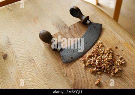 vintage cutter knife and nuts on wooden board - chopping nuts for healthy dessert Stock Photo