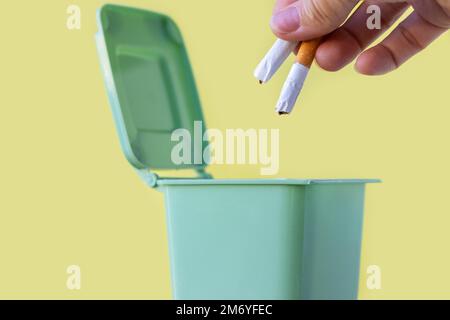 woman hand throwing in trash mini small garbage bin can broken smartphone white paper napkin towel,burnt matches or broken cigarette,lithium battery Stock Photo