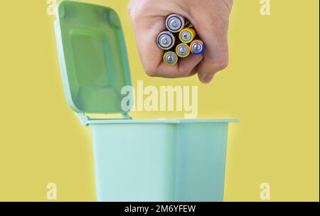 woman hand throwing in trash mini small garbage bin can broken smartphone white paper napkin towel,burnt matches or broken cigarette,lithium battery Stock Photo