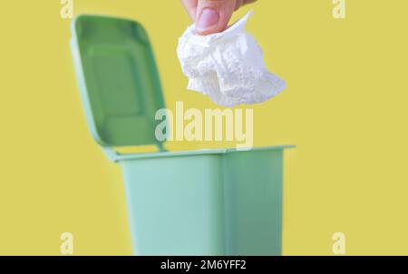 woman hand throwing in trash mini small garbage bin can broken smartphone white paper napkin towel,burnt matches or broken cigarette,lithium battery Stock Photo