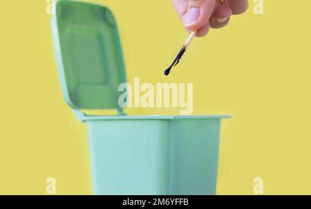 woman hand throwing in trash mini small garbage bin can broken smartphone white paper napkin towel,burnt matches or broken cigarette,lithium battery Stock Photo