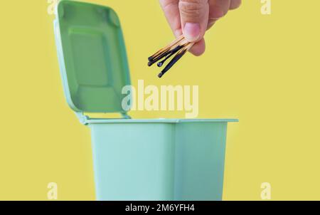 woman hand throwing in trash mini small garbage bin can broken smartphone white paper napkin towel,burnt matches or broken cigarette,lithium battery Stock Photo