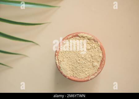 The wooden bowl with rehydrated henna on table Stock Photo