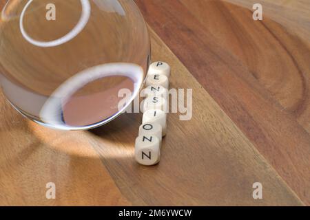 A crystal ball next to a row of block letters spelling out the word pension, future of pension, financing retirees, future prediction of pension value Stock Photo