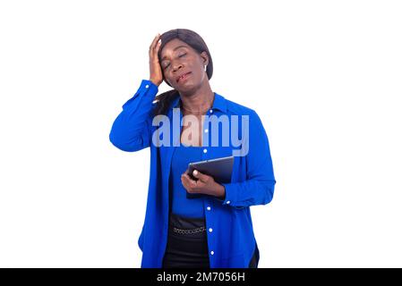 beautiful businesswoman in blue shirt standing on white background with hand on head holding tablet while thinking . Stock Photo