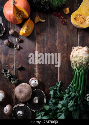 Fall food ingredients on dark wooden background with text space. Flat-lay of autumn vegetables, berries and mushrooms from local market. Vegan ingredi Stock Photo