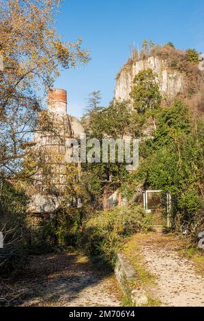 Castelveccana, Italy- 12-27-2022: Red brick chimneys and abandoned furnaces with vegetation covering them in Caldè on Lake Maggiore Stock Photo