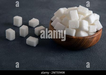 White sugar cubes in bowl on a dark background Stock Photo