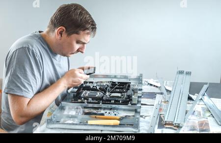 Man engineer,collector.Independent self computer assembly. Mounting in sockets processor,random access memory RAM,motherboard,fan. Assembly of home cr Stock Photo