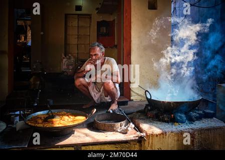 https://l450v.alamy.com/450v/2m70d44/pushkar-india-november-7-2019-street-food-stall-cook-smoking-while-cooking-sweet-puri-bread-and-rabri-sweet-condensed-milk-based-dish-in-street-2m70d44.jpg