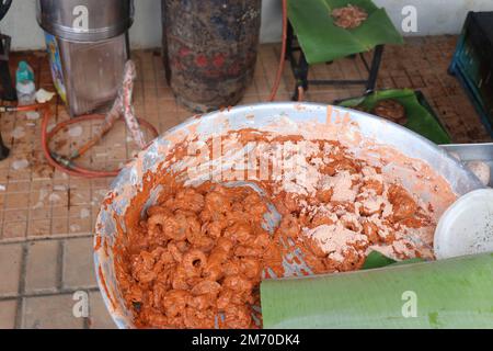 Vessel full of marinated prawns mixed with spices and other ingredients ready to be fried in deep oil Stock Photo