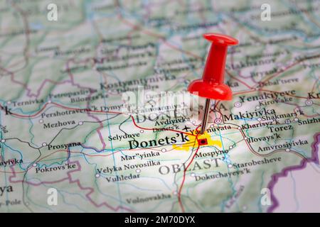 A red push pin marking the city of Donetsk in Ukraine which is a target of Russian invasion in the Special Military Operation or war Stock Photo