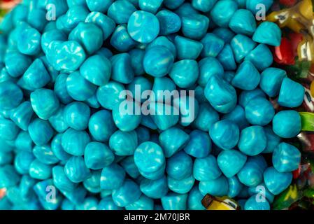 many colored marmalade candies laid out on a flat surface; dessert for the holiday; sweet gifts for children; texture and background with small candie Stock Photo