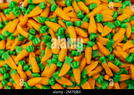 many colored marmalade candies laid out on a flat surface; dessert for the holiday; sweet gifts for children; texture and background with small candie Stock Photo