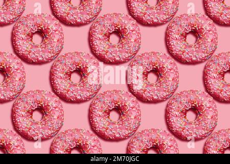 Donuts with sprinkles on pink background. Seamless pattern. Bright sugar concept in top view. Junk sweet food. Stock Photo