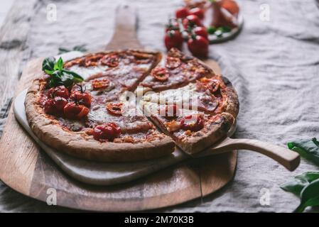 Ham and mozzarella pizza on a cutting board Stock Photo