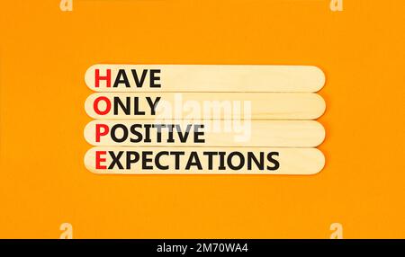 HOPE have only positive expectations symbol. Concept words HOPE have only positive expectations on stick on beautiful orange background. Business HOPE Stock Photo