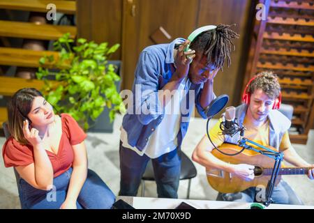 young artist singer African American rapper performs during a web radio broadcast, live streaming organized in home environment with modern technologi Stock Photo