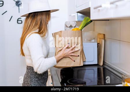 Woman coming home from the supermarket with the purchase of vegetables and fruits Stock Photo