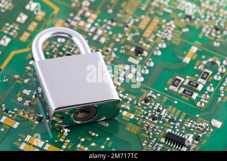 Computer security concept. Silver padlock on green computer circuit board Stock Photo