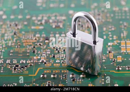 Computer security concept. Silver padlock on green computer circuit board Stock Photo