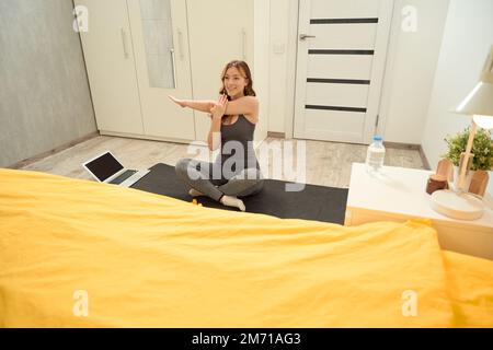 Pleased athletic young woman doing upper-body workout Stock Photo