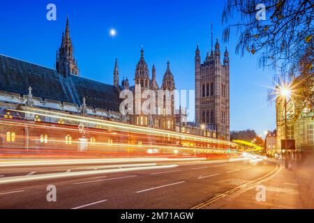 Cars pass beside the Westminster Palace in London England UK at twilight Stock Photo