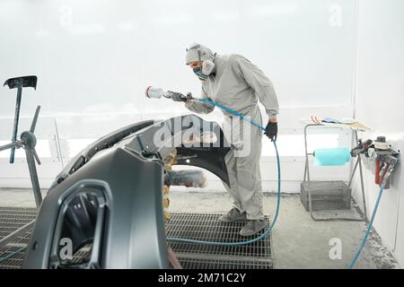 Male doing color restoration for automobile parts Stock Photo