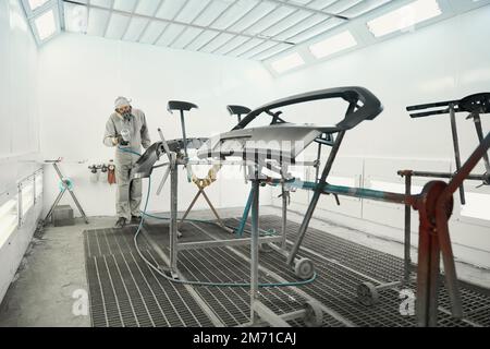 Worker doing color restoration for car parts Stock Photo