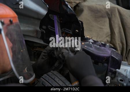 Professional mechanic working in the garage, repairs cars Stock Photo