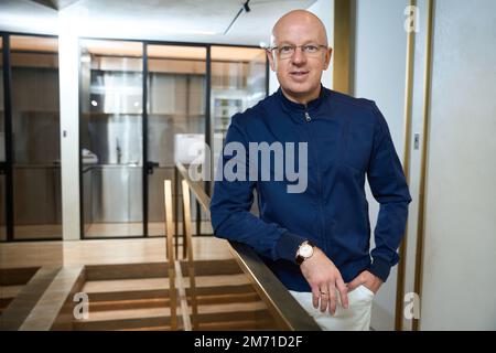 Middle-aged man stands in the lobby leaning on the railing Stock Photo