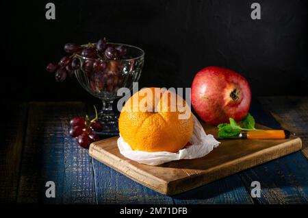 Still life with orange pomegranate and grapes in still of a Dutch master Stock Photo