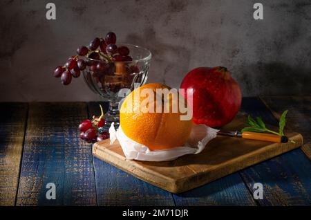 Still life with orange pomegranate and grapes in still of a Dutch master Stock Photo