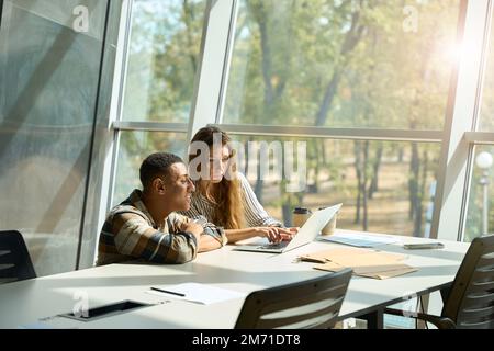 Happy two colleagues discussing new project in the office Stock Photo