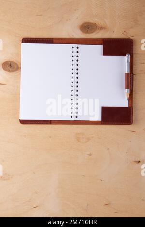 Blank notepad in leather cover with graphite pencil lie on wooden desk Stock Photo