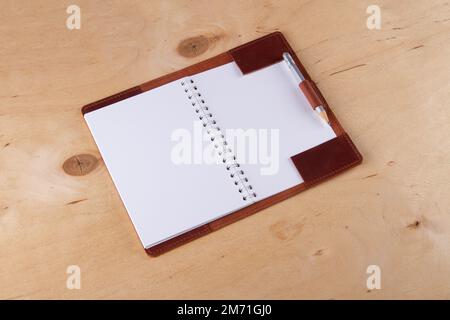 Blank scratchbook in leather cover with graphite pencil lie on wooden desk Stock Photo