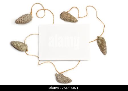 Pine cones and a blank white paper on a white background Stock Photo