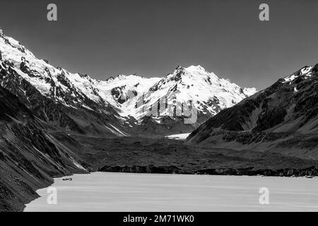 High contrast black-white view of the largest glacier in New Zealand off slopes of Mt Cook feeding to Tasman lake on a sunny bright day. Stock Photo
